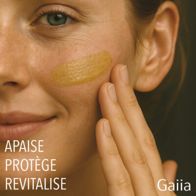 Femme appliquant crème apaisante sur visage souriant.