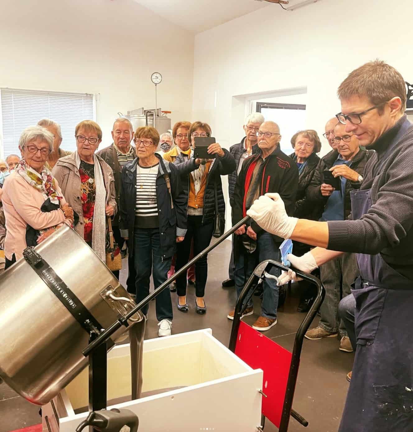 Démonstration de fabrication artisanale devant un groupe.