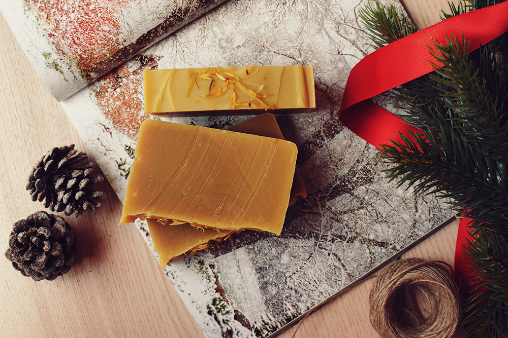 Savon artisanal avec pommes de pin et décor festif.