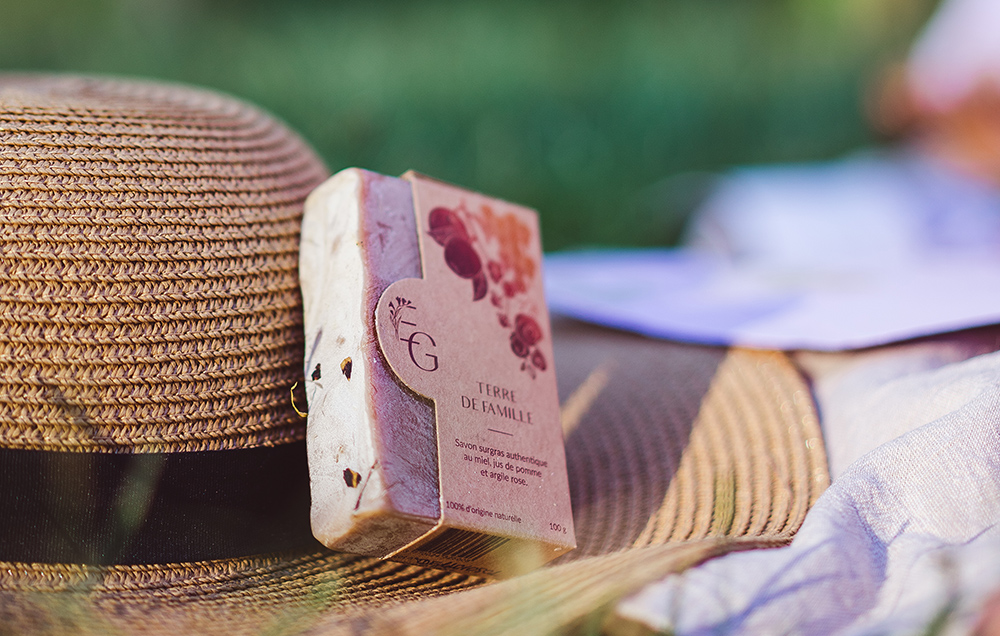 Savon artisanal sur chapeau de paille au soleil.
