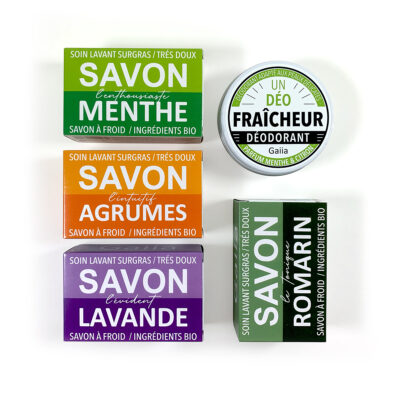 Savons bio et déodorant sur surface blanche.